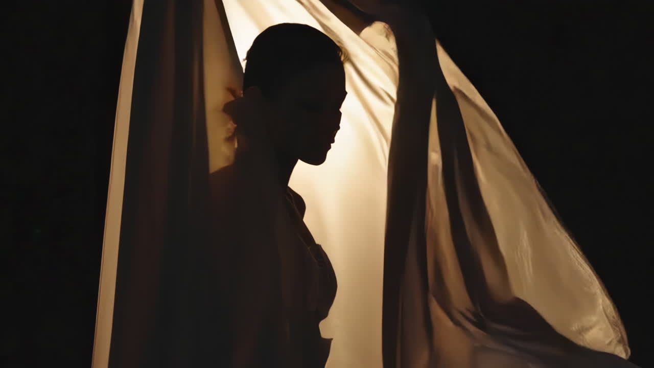 Silhouette of woman with flowing fabric
