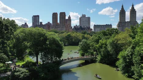 Touristen-Werden-Gesehen,-Wie-Sie-Auf-Der-Bogenbrücke-Und-Ruderbooten-Auf-Dem-See-Darunter-Im-Central-Park-New-York-Laufen?