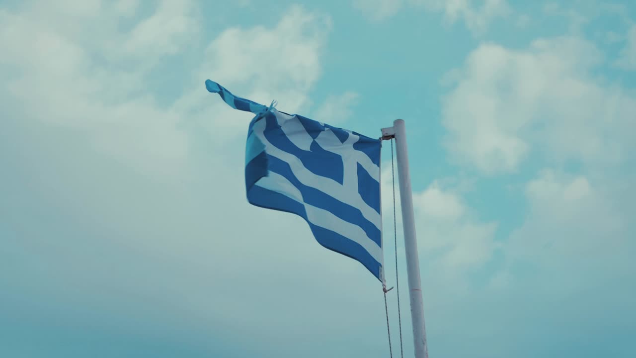 Slidt græsk flag blæser i vinden under overskyet himmel, 180 FPS.