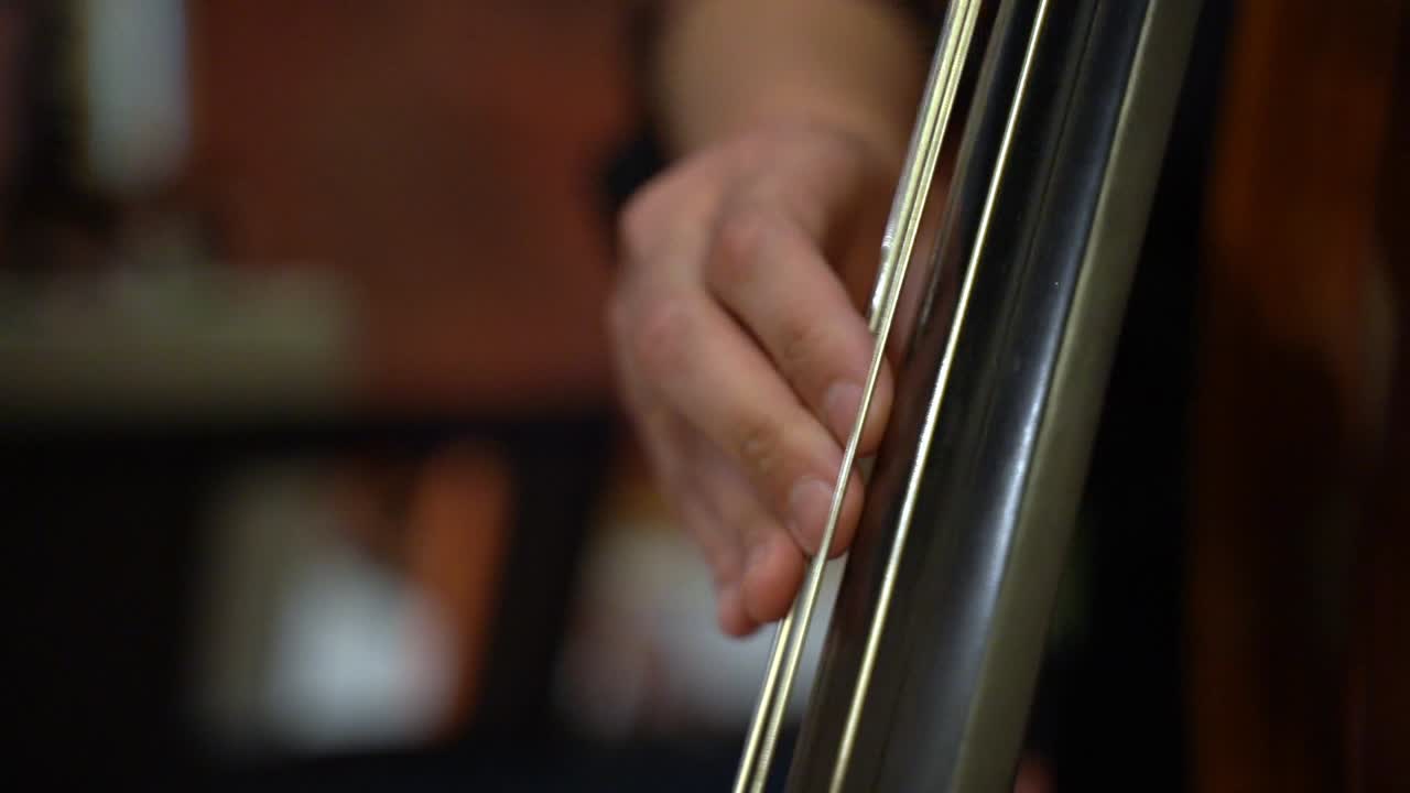 Close-up of a Musician's Hand Playing the Double Bass