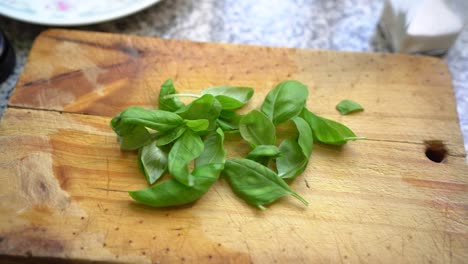 The-green-leaves-of-Basil-herb-on-cutting-board