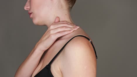 close-up on the neck of a woman feeling pain and massaging herself with her hand to cause relief