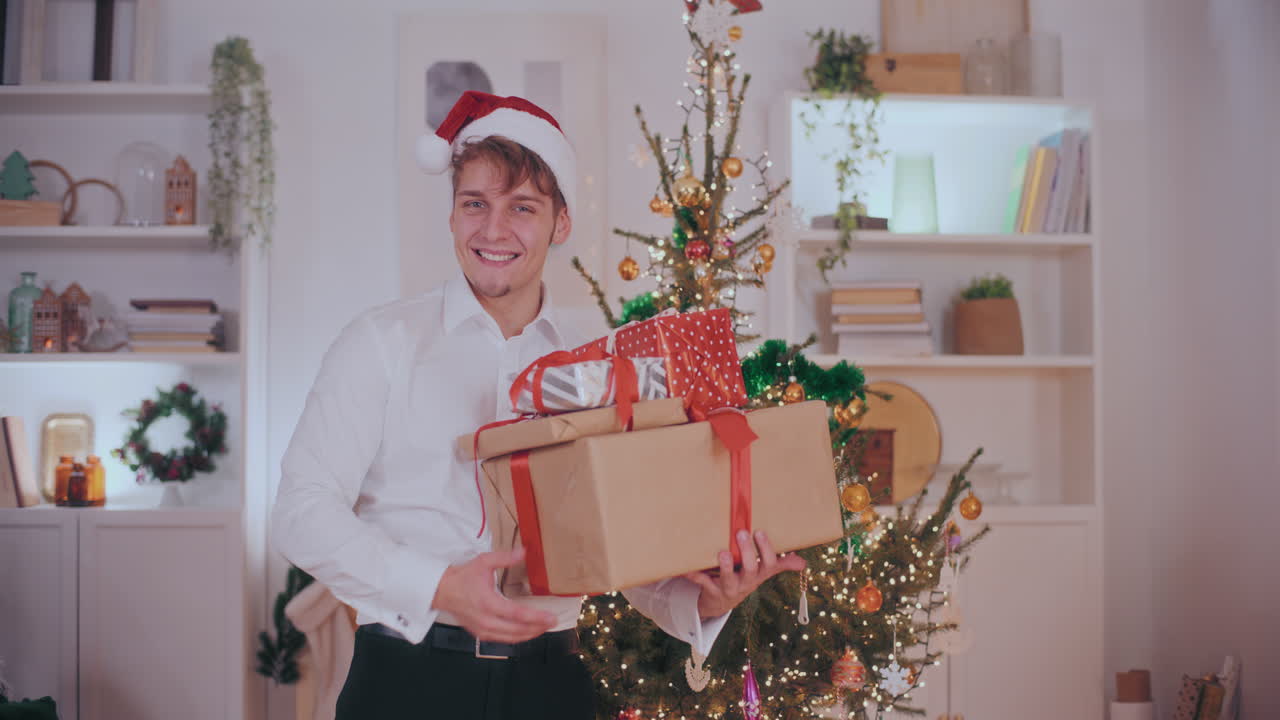 hombre guapo llevando varios regalos de navidad en casa