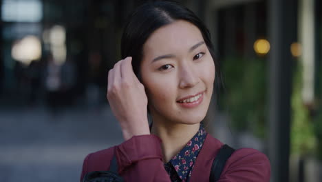 portrait-cute-young-asian-woman-student-smiling-running-hand-through-hair-enjoying-relaxed-urban-lifestyle-beautiful-independent-female-in-city-slow-motion