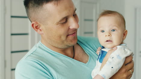 padre joven feliz sosteniendo a su hijo dos meses sonriendo la alegría de la paternidad infancia feliz