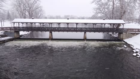 roofed bridge in america covered in snow, aerial drone view