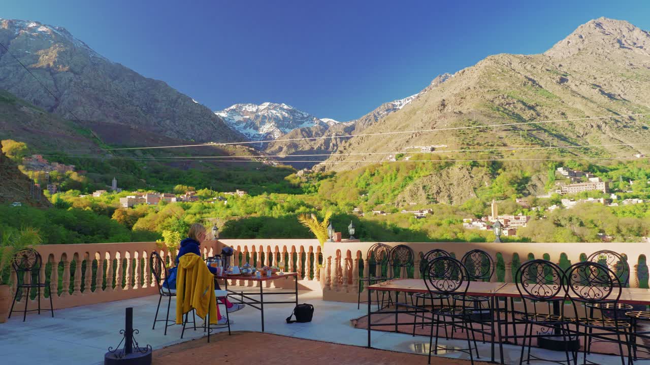 turista tomando café da manhã no terraço da cobertura em imlil com vista para toubkal, marrocos