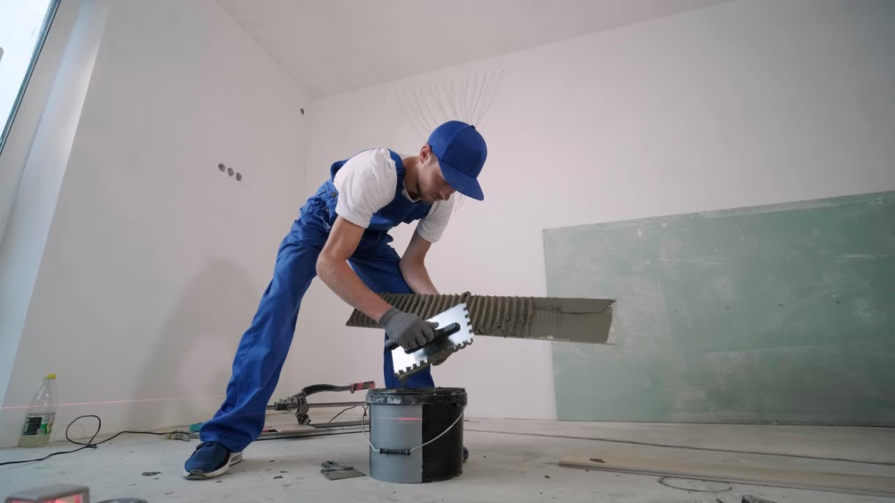 Installing ceramic floor tiles - measuring and cutting the pieces. Construction, renovation, repair apartment. Cuts tile. Tile cutting