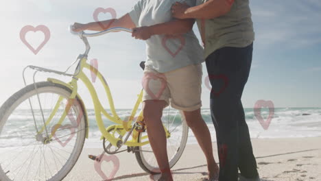 walking on beach, elderly couple with bicycle, heart animation in scene
