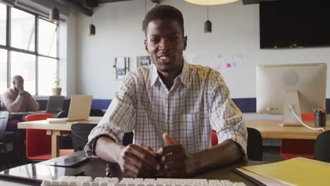 Retrato-De-Un-Feliz-Hombre-De-Negocios-Afroamericano-Mirando-La-Cámara-En-La-Oficina