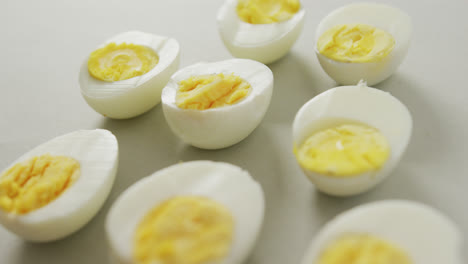 video of close up of halves of hard boiled eggs on grey background