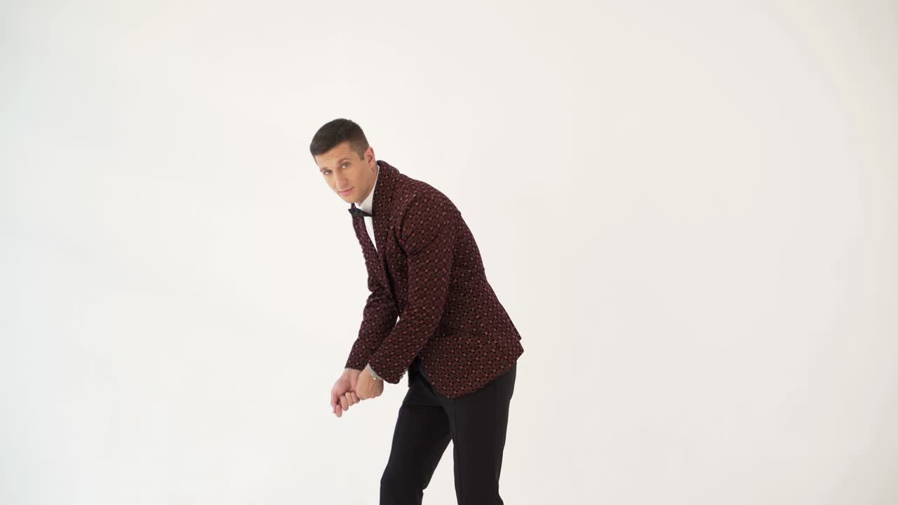 charismatic man in a brown suit is showing a typical golf player on the field. Parody in the studio