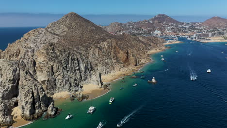 tiro de drones comenzando en botes y luego revelando las montañas y playas de cabo san lucas méxico