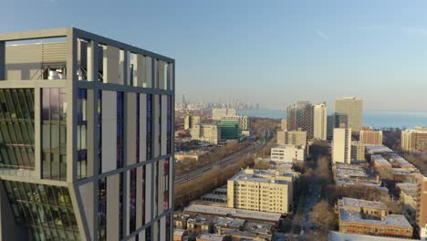 Drone-Flies-Past-Modern-Building,-Reveals-Chicago-Skyline-in-Distance