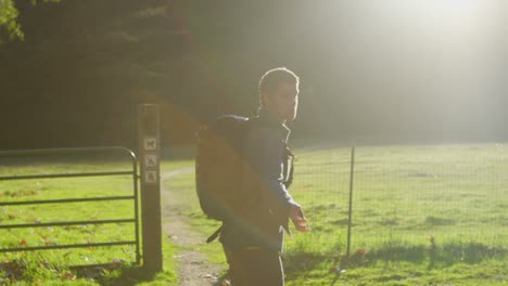 a couple runs through a gate towards a forest