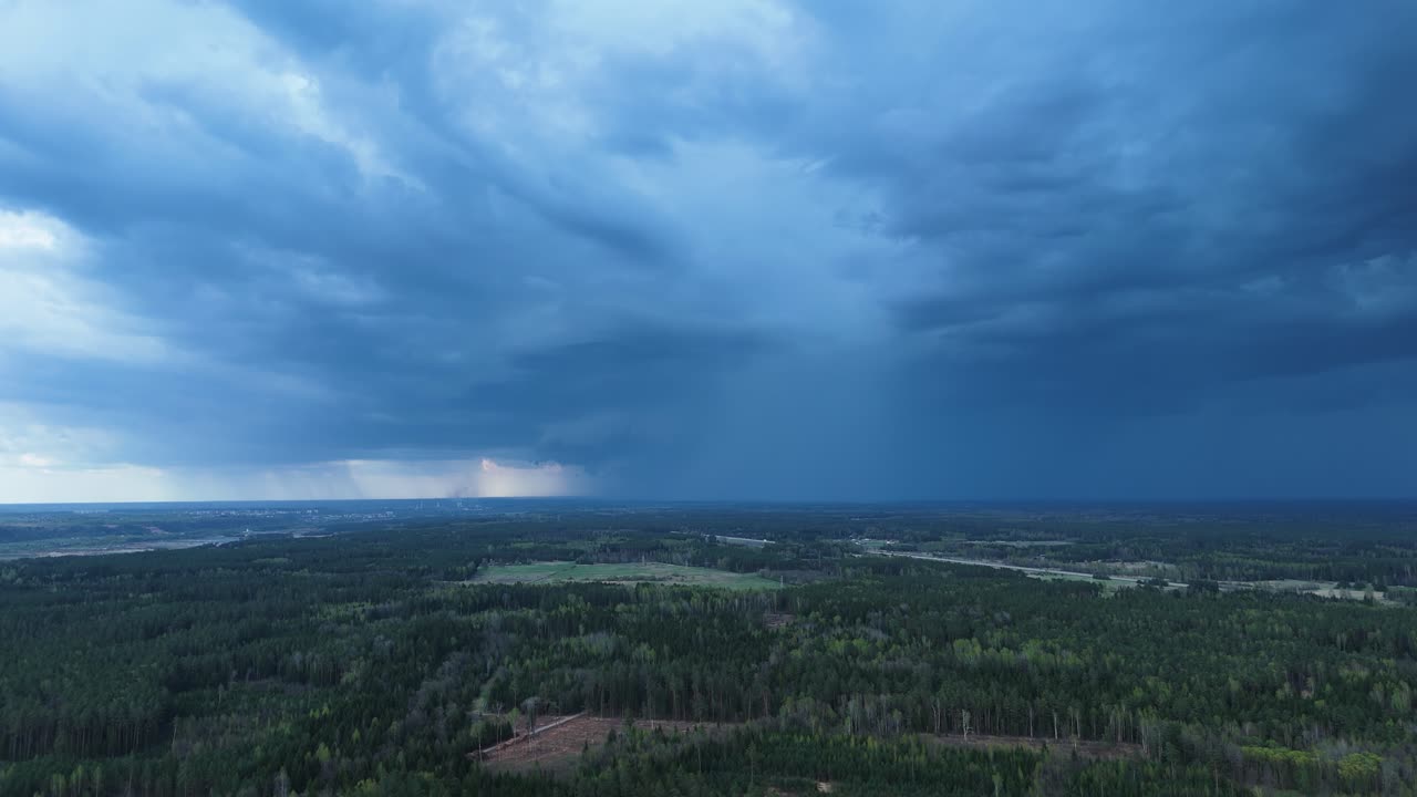 Powerful rainclouds flowing above Lithuanian countryside, aerial time lapse view