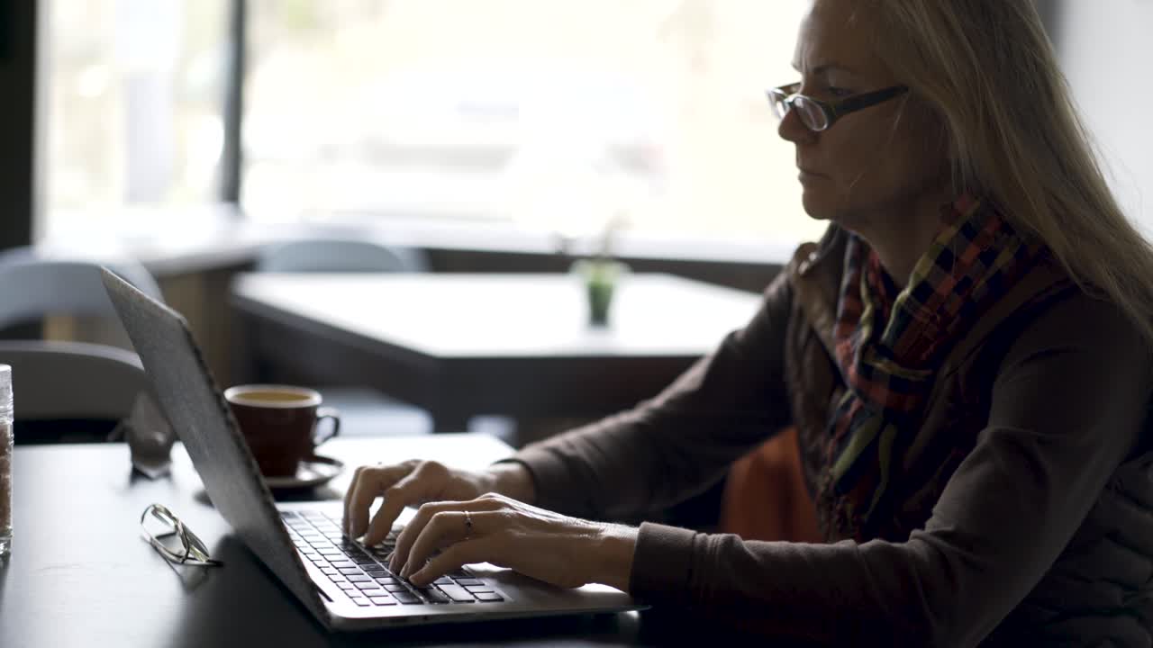 Woman working on a laptop in a cafe