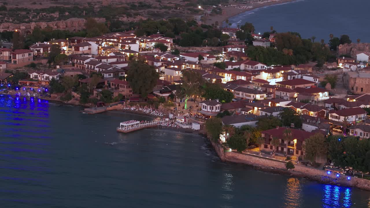 vista aérea volando a través de la ciudad vieja, casas de barrio frente al mar iluminadas por pavos y costa marina