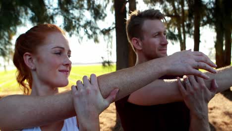 Couple-performing-stretching-exercise-in-olive-farm