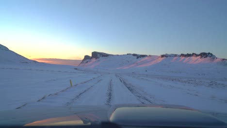 conduciendo por carreteras heladas en islandia en invierno hacia el amanecer en febrero