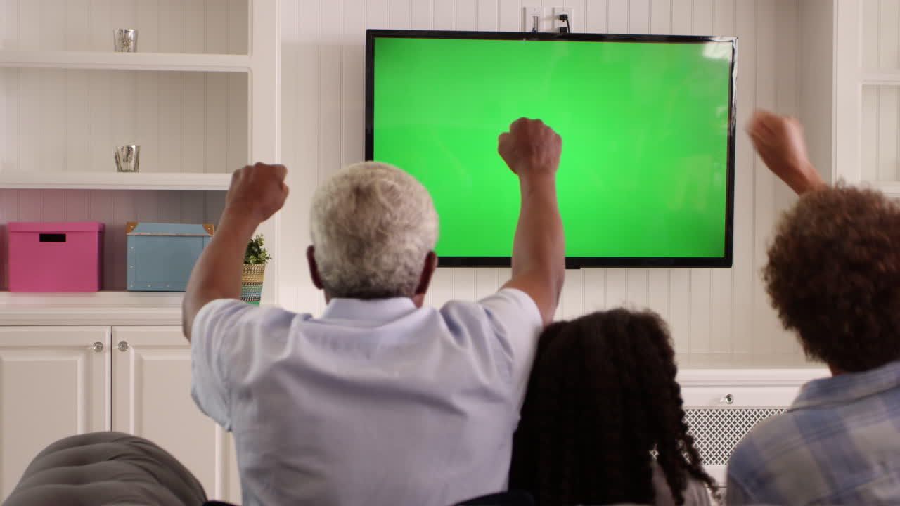 Rear View Of Family Watching Green Screen TV Shot On R3D