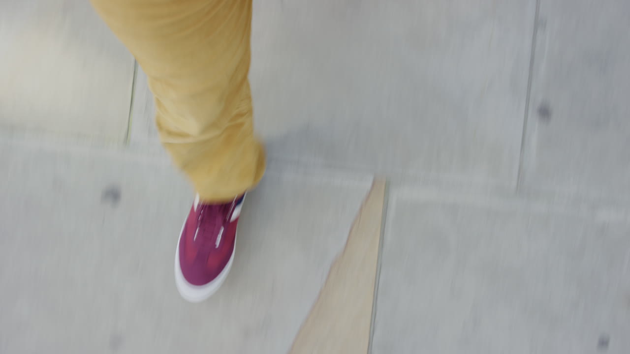 man walking on sidewalk wearing colorful shoes strolling casual in city top view