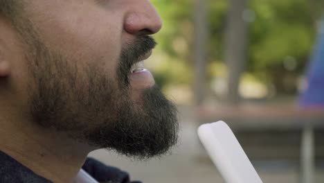 foto recortada de un hombre barbudo hablando por teléfono celular