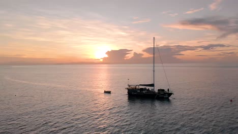 luxury wood sailing boat at sea at sunrise. 4k drone (close orbit shot).