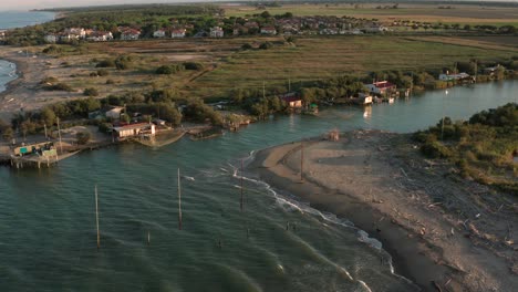 aerial shot of the valleys near ravenna where the river flows into the sea with the typical fishermen's huts