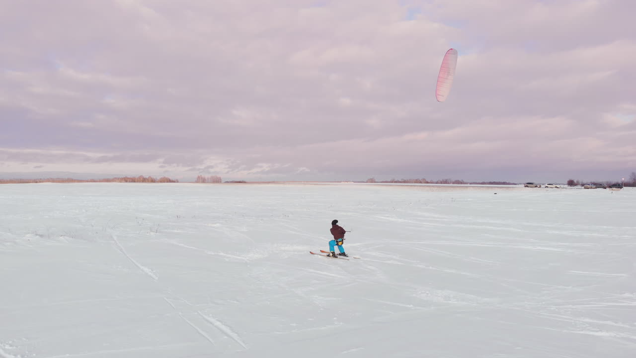 un hombre esquiando en una cometa de nieve sostiene una cámara de acción y toma una foto de un selfie.