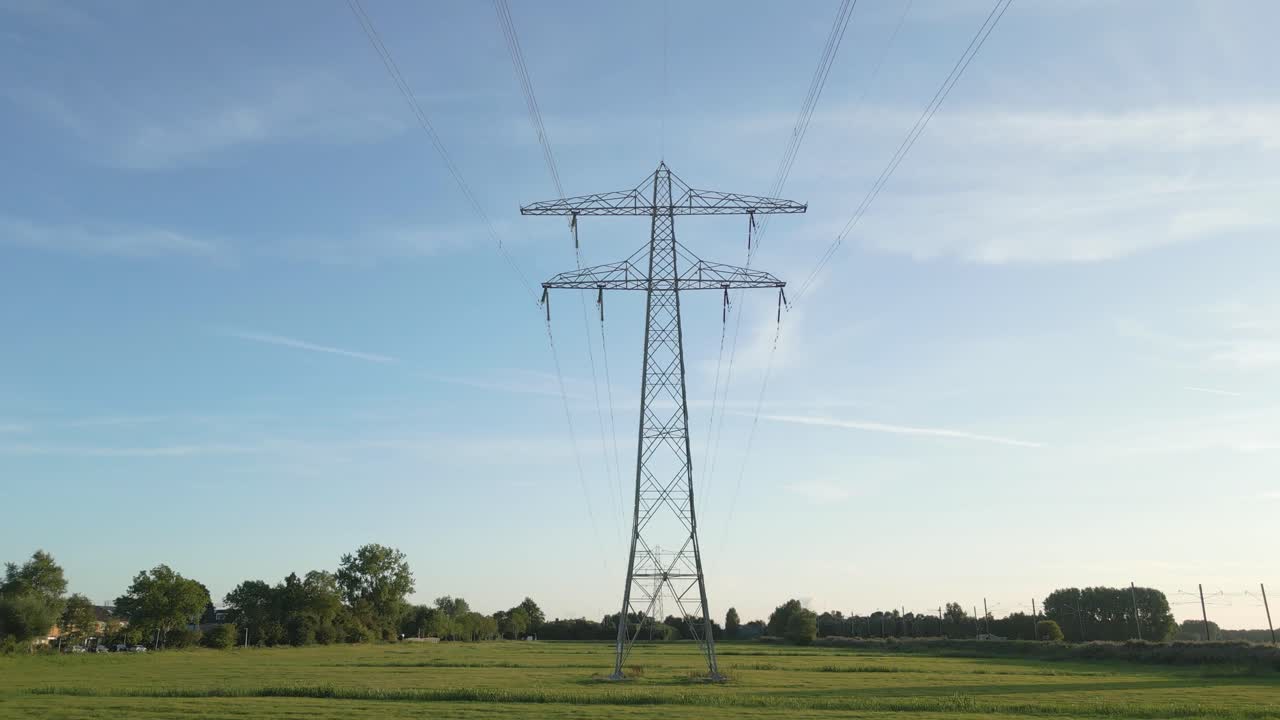 Aerial drone wide shot landscape shot of a high voltage pylon with power lines stretching into the distance