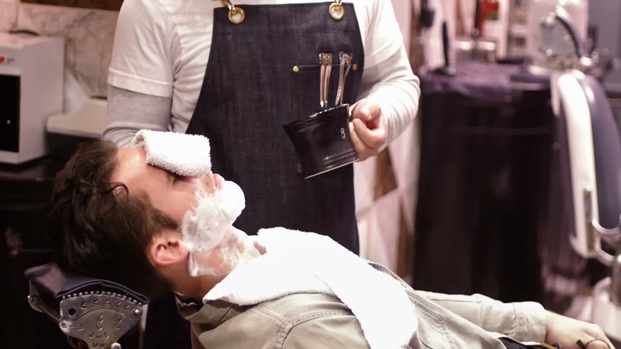 Mand får barberet sit skæg med barberkost