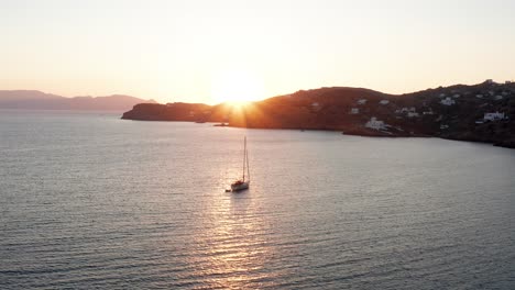 Vista-Aérea-Del-Barco-Durante-La-Puesta-De-Sol-En-La-Playa-De-Magganari-En-La-Isla-De-Ios-Grecia