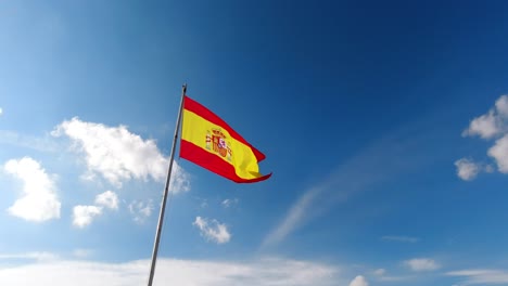 Vista-Portátil-De-La-Colorida-Bandera-Española-Ondeando-Contra-El-Cielo-Azul