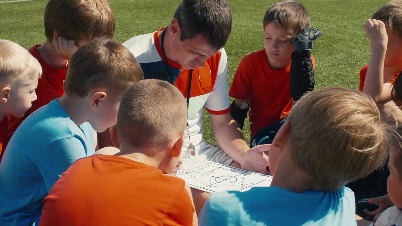 축구 멘토가 아이들을 가르치고 있습니다.