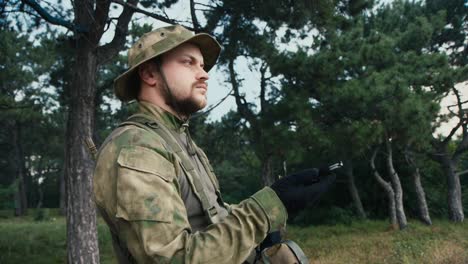 a man in camouflage looks at a compass 2