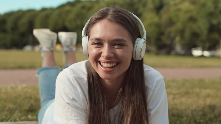 Woman in Headphones Lying on Lawn