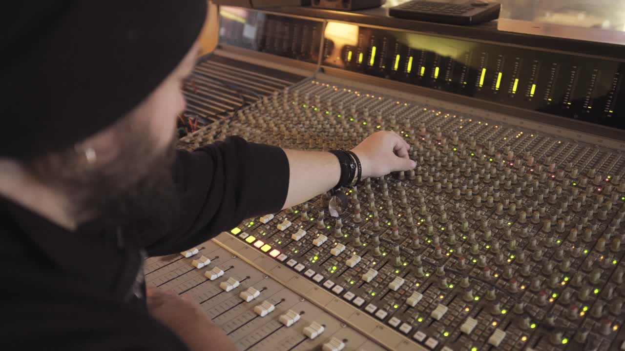 hombre en un instrumento de ecualizador en un estudio