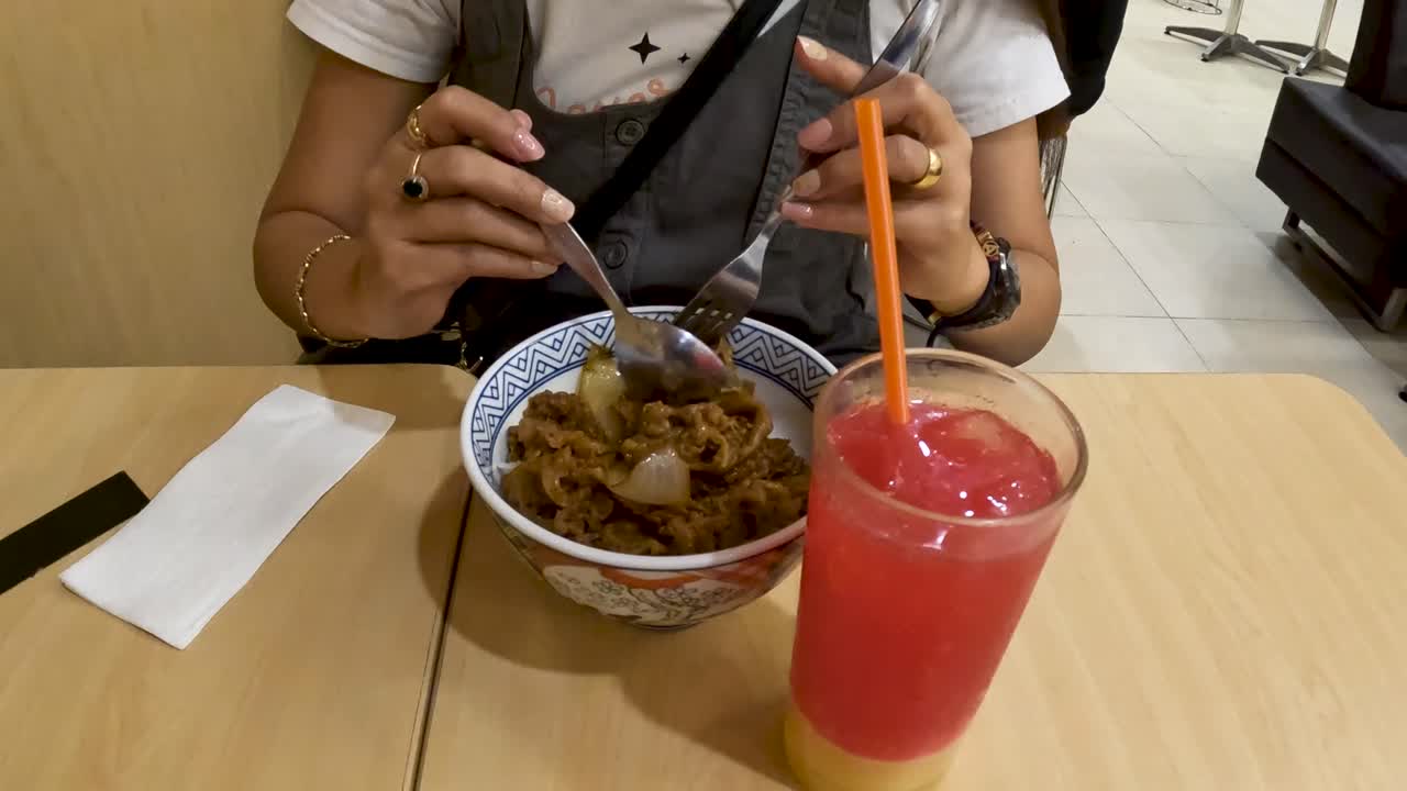 mujer irreconocible come comida japonesa en un restaurante en yogyakarta, indonesia
