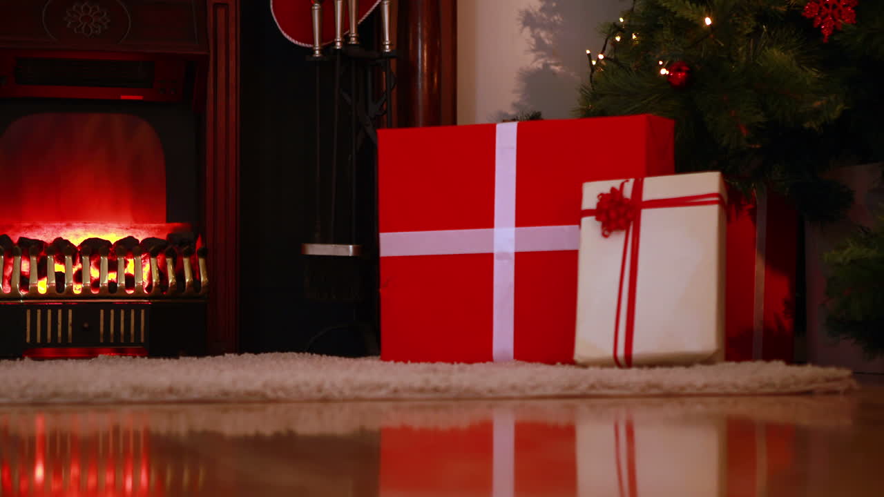 Julenissen leverer gaver under juletreet