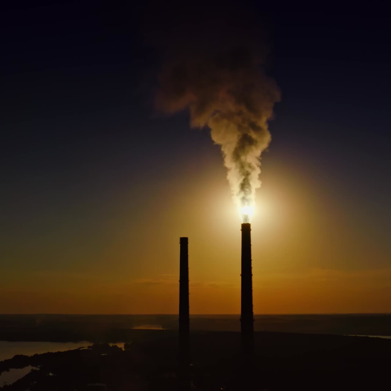 Fumo massiccio dalle ciminiere contro la luna. Sagoma scura di ciminiere industriali di notte. Fumi densi che si disperdono nell'aria la sera. Disastro ecologico. Vista aerea