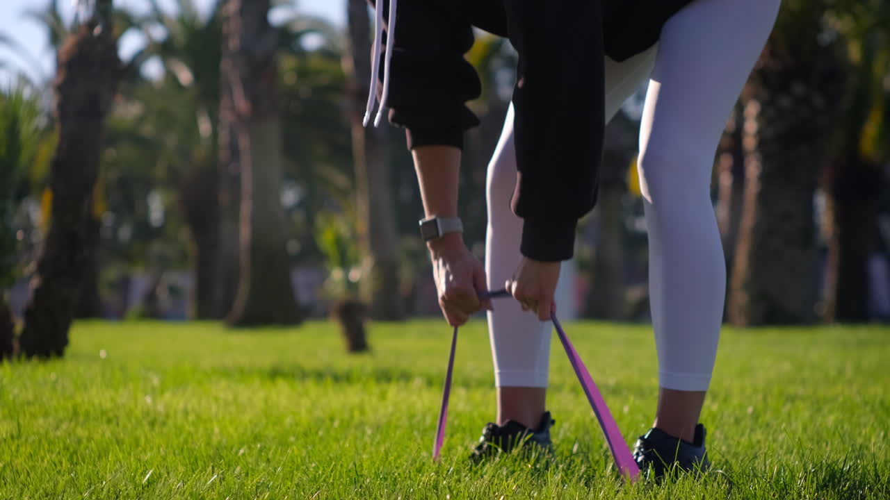 야외에서 저항 밴드로 운동하는 여성