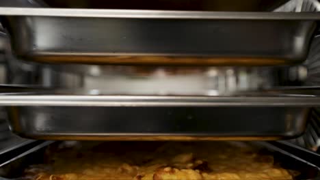 close-up view of a dish in a stainless steel tray inside a commercial kitchen oven