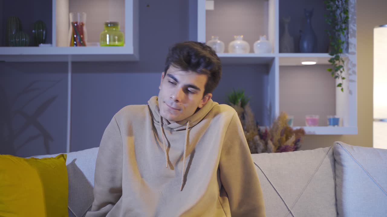 집에서 소파에 앉아 있는 우울하고 외로운 남자.