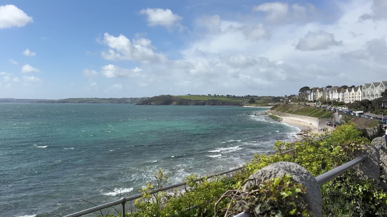 Atemberaubende Weitwinkelaufnahme fängt Gyllyngvase Beach und Pendennis Point in Falmouth, Cornwall, Großbritannien, bei hellem Tageslicht ein, mit dynamischen Wellen, lebendigem Grün, einer Küstenstadt und dramatischem Himmel. (200)