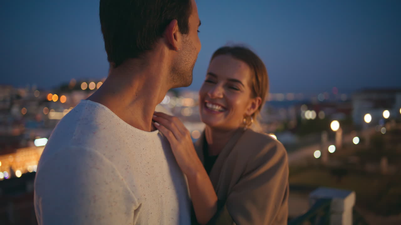 Happy sweethearts having fun laughing on evening date closeup. Cuddling pair