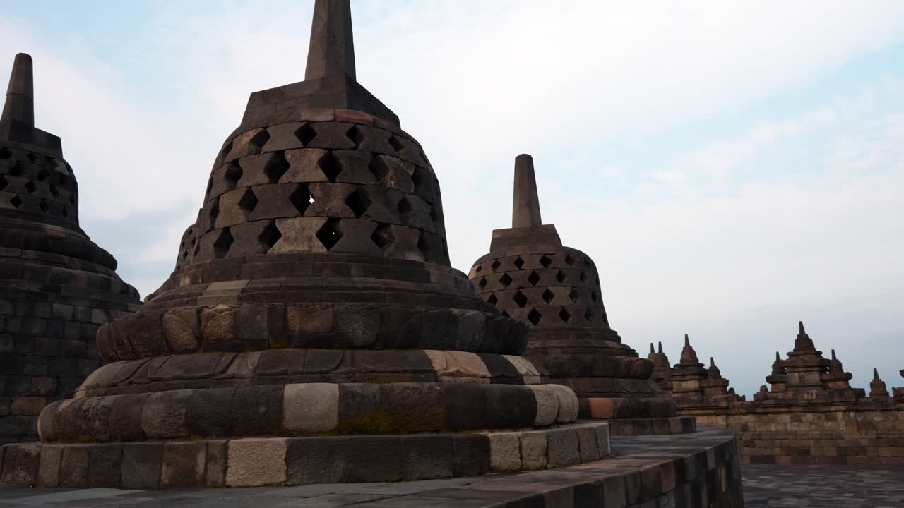 Panoramica a campana degli iconici stupa a forma di campana sulla cima del tempio di Borobudur al tramonto