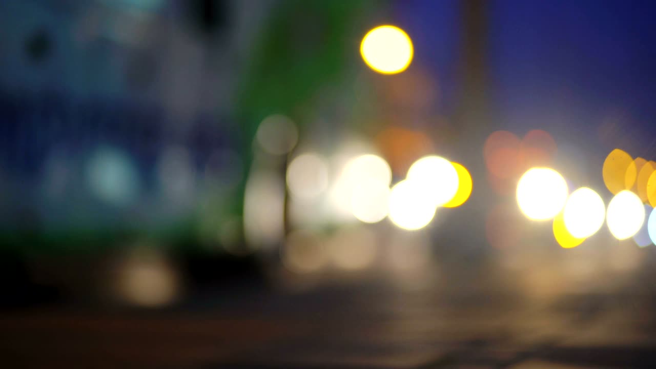 다채로운 트래픽 라이트 보케는 밤의 도시 거리에 서클합니다. 추상적인 배경