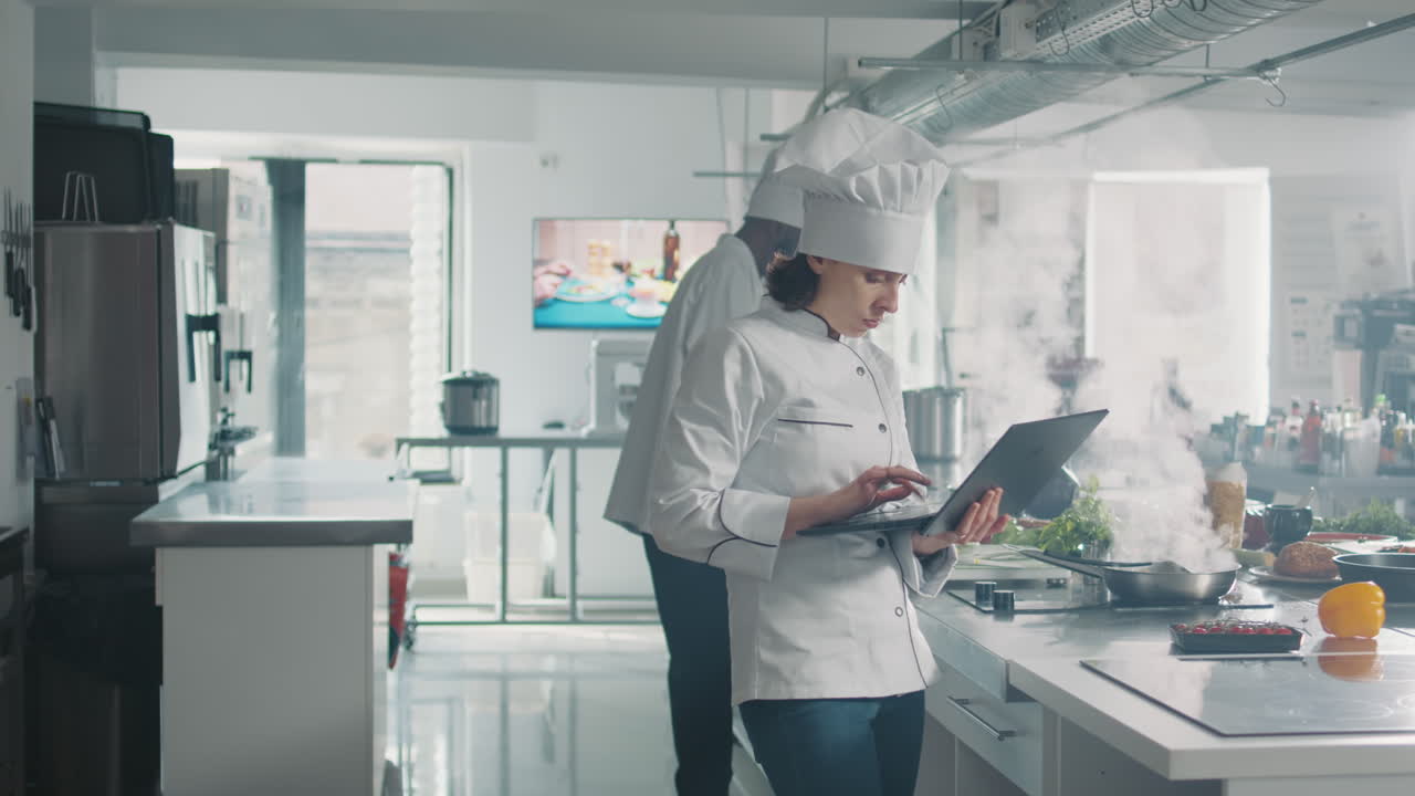 Female cook studying professional food recipe on laptop