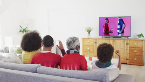 Familia-Birracial-Viendo-Televisión-Con-Diversos-Jugadores-De-Rugby-Masculinos-Con-Pelota-En-La-Pantalla